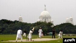 ভারতের স্থানীয় একটি মাদ্রাসার মুসলিম ছাত্ররা কলকাতায় মাঠে ক্রিকেট খেলছে।পেছনে ভিক্টোরিয়া মেমোরিয়াল। ১৮ জুলাই ২০০৮।(ছবি-এএফপি/দেশকল্যাণ চৌধুরী)