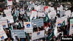 FILE - Employees of Pakistan's biggest television station Geo TV attend a protest against the Pakistan Electronic Media Regulatory Authority after the station's license was suspended, in Karachi, May 22, 2014.