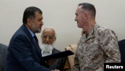 International Security Assistance Force (ISAF) commander General Joseph Dunford (r) and Afghan Defense Minister Bismillah Khan Mohammadi during a ceremony handing over the Bagram prison to Afghan authorities, at the U.S. airbase in Bagram, Mar 25, 2013.