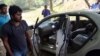 Qamar Abbas (2L) the son of slain government prosecutor Chaudhry Zulfiqar looks at the bullet-riddled car of his father after an attack by gunmen in Islamabad on May 3, 2013.