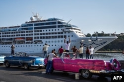 Cubans watch as the first U.S.-to-Cuba cruise ship to arrive in the island nation in decades glides into the port of Havana on May 2, 2016.