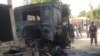 Policemen stand guards at a burnout truck following an attacked by Boko haram militants near an Air force base in Maiduguri, December 2. 2013. 