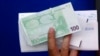 Foto ilutrasi menunjukkan sebuah tangan yang memegang uang Euro yang baru ditarik dari sebuah mesin ATM di Athena, Yunani, pada 13 Juni 2012. (Foto: Reuters/Yannis Behrakis)