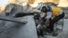 A member of the Syrian Civil Defense, also known as the White Helmets, searches through the wreckage of their center, which was destroyed by government forces in the town of al-Tamana on the southern edges of the rebel-held Idlib province, Sept. 6, 2018.