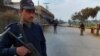 A Pakistani police officer stands guard at a checkpoint on a road leading to the site of bomb explosion in Bannu, Pakistan, Jan. 19, 2014.