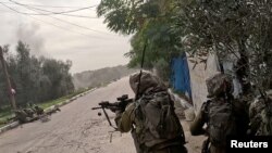 Israeli soldiers operate in a location given as Khan Younis