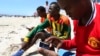 FILE - A Somali man browses the Internet on his mobile phone at a beach in Somalia's capital Mogadishu, Jan. 10, 2014.