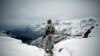 FILE - A Pakistani Army soldier with the 20th Lancers Armored Regiment stands atop the 8000-foot mountain during a patrol near his outpost, Kalpani Base, in Pakistan's Dir province on the Pakistan-Afghan border.