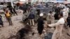 FILE: The Pakistani Taliban, fighting to topple the government through terrorist attacks, is dividing. In Peshawar, a sprawling city on Pakistan's border with Afghanistan, police gather evidence after a suicide bombing that killed at least nine bystanders