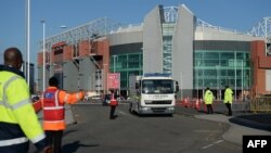 Event staff guide a British Army Bomb Disposal Unit truck as it leaves Old Trafford stadium in Manchester, north west England, on May 15, 2016, after the English Premier League football match between Manchester United and Bournemouth was canceled..