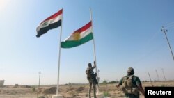 İraq ordusunun əsgəri kürd bayrağını endirir.