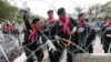 Thai police remove barbed wire outside the city police headquarters in Bangkok, Thailand, Dec. 3, 2013.