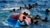 FILE - Migrants swim next to their overturned wooden boat during a rescue operation by Spanish NGO Open Arms at south of the Italian Lampedusa island in the Mediterranean Sea, Aug. 11, 2022. 