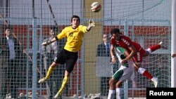 Pakistan's goalkeeper Saqib Hanif (L) jumps to make a save during a friendly football match against Afghanistan in Kabul, Afghanistan, Aug. 20, 2013.