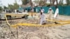 Pakistani security officials examine a crater caused by overnight suicide bombing in the southern city of Sukkur. on July 25, 2013. 