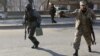Afghan police officers run to Kabul traffic police headquarters as it is attacked by insurgents in Kabul January 21, 2013.