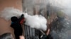A pro-Russian protester fires a fire extinguisher at riot police inside at a police station building in Odessa, Ukraine, Sunday, May 4, 2014. Several prisoners that were detained during clashes that erupted Friday between pro-Russians and government suppo