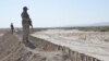 Pakistani soldiers stand guard near the trench near the Afghanistan border.