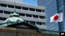 FILE - A Japanese flag flutters at the Bank of Japan headquarters in Tokyo, July 29, 2022. 