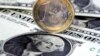 FILE - A euro coin sits atop US one-dollar notes in Gelsenkirchen, Germany. 