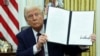 Президент Дональд Трамп подписывает исполнительные указы в Овальном кабинете Белого дома, 23 января 2025 года. REUTERS/Kevin Lamarque.