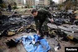 A Russian soldier checks a burned medical tent after rebels launched a mortar shell at a field hospital in west Aleppo, Syria, Dec. 5, 2016.
