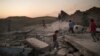 FILE - Children play on debris in a neighborhood retaken by Iraqi security forces during fighting against Islamic State militants in West Mosul, Iraq, June 25, 2017.
