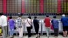 Investors look at computer screens showing stock information at a brokerage house in Shanghai, China, July 8, 2015.