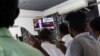 Pendukung Presiden Ramil Wickremesinghe di pinggiran Kolombo, Sri Lanka, mendengarkan pidatonya melalui siaran televisi, setelah dewan eksekutif Dana Moneter Internasional (IMF) menyetujui pinjaman $3 miliar, 21 Maret 2023. REUTERS/Dinuka Liyanawatte