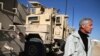 FILE - U.S. Secretary of Defense Chuck Hagel stands next to MRAP vehicles after speaking to U.S. troops at Camp Bastion, Afghanistan, Dec. 8, 2013. 
