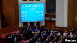 资料照：在北京人大会堂举行的全国人民代表大会第五次全体会议上，大屏幕显示习近平以赞成票2970、反对票0，弃权票0的全票通过的投票结果连任国家主席。（2018年3月17日）
