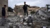 Ibrahim Hasouna, tengah, satu-satunya yang selamat di antara keluarganya dalam pemboman Israel, berdiri di tengah puing-puing rumahnya di kota Rafah, Jalur Gaza selatan, 13 Februari 2024.
