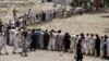 People, who fled the military offensive against Pakistani militants in North Waziristan, line up to receive food supply from the army in Bannu, in Pakistan's Khyber-Pakhtunkhwa province, June 25, 2014.