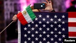 Warga memegang bendera Iran dan Amerika Serikat ketika orang-orang Iran-Amerika dari seluruh California berkumpul di Los Angeles untuk berpartisipasi dalam Konvensi California untuk Iran yang Bebas di California, AS, 11 Januari 2020. (Foto: REUTERS/ Patrick T. Fallon)