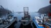 FILE - A fisherman sits on his boat in a small port on the island of Baengnyeong.