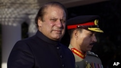 Newly elected Prime Minister of Pakistan Nawaz Sharif, left, arrives at the Prime Minister''s house to review guards of honor in Islamabad, Pakistan, June 5, 2013. 