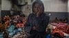 FILE - A migrant holds his head as he stands in a packed room at the Tariq Al-Matar detention center on the outskirts of the Libyan capital Tripoli, Nov. 27, 2017.