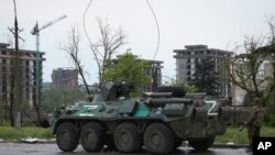 Un vehículo blindado de la milicia de la República Popular de Donetsk está detenido no lejos de la asediada acería Azovstal en Mariúpol, en territorio bajo control de la República Popular de Donetsk, este de Ucrania, 19 de mayo de 2022.