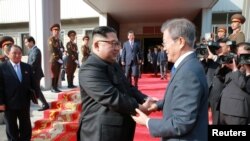 朝鲜官方通讯社朝中社2018年5月27日发布的韩国总统文在寅（右）与朝鲜领导人金正恩在两国边境板门店会晤时握手的照片。