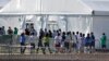 ARCHIVO - Esta foto de archivo del 19 de febrero del 2019 muestra niños entrando en fila al centro de detención Albergue Temporal Homestead para Niños no Acompañados, en Homestead, Florida. (AP Foto/Wilfredo Lee, Archivo)
