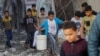 Trẻ em Palestine xách đồ di chuyển khỏi địa điểm xảy ra các cuộc tấn công của Israel, giữa bối cảnh xung đột đang diễn ra giữa Israel và nhóm Hồi giáo Palestine Hamas, tại Khan Younis, phía nam Dải Gaza, vào ngày 6/12/2023.