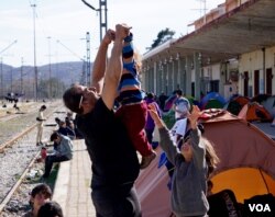 A Syrian father plays with his son. (Jamie Dettmer for VOA)