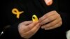 A supporter of Junts per Catalunya or Together for Catalonia makes a yellow ribbon in support of Catalonian politicians who have been jailed on charges of sedition, during a campaigning event in Barcelona, Spain, Dec. 19, 2017. 