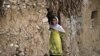 FILE - An Afghan refugee girl outside her home in slums of Islamabad, Pakistan.