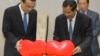 China's Premier Li Keqiang, left, pulls a symbol of China-Cambodia Heart Journey, together with his Cambodian counterpart Hun Sen, center, during a signing ceremony at Peace Palace in Phnom Penh, Cambodia, Thursday, Jan. 11, 2018. Cambodia and China on Thursday signed nearly 20 agreements worth several billion dollars to develop the impoverished Southeast Asian country's infrastructure, agriculture, and healthcare. (AP Photo/Heng Sinith)
