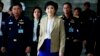 Prime Minister Yingluck Shinawatra, center, leaves the Thai Air Force headquarters after a cabinet meeting in Bangkok, Thailand, Feb. 25, 2014.