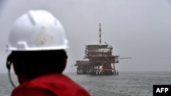 Seorang pekerja melihat anjungan Gas ENI PCW-C Italia di laut Adriatik. (Foto: AFP)