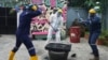 People wearing protective gear use sledgehammers to break a television set to vent their anger outside the Shadow Rage Room in Lagos, Nigeria, July 28, 2024.