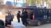 Anggota keamanan berdiri di dekat kendaraan polisi menyusul ledakan setelah peluru artileri jatuh di Nansan, Provinsi Yunnan, Cgina, dalam tangkapan layar yang diperoleh dari video media sosial, dirilis pada 3 Januari 2024. (Video Diperoleh Reuters/via REUTERS)