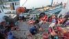 Migrant workers work on fishing boats at a pier in Prachuabkhirikhant province, southern Thailand Tuesday, March 4, 2014. 
